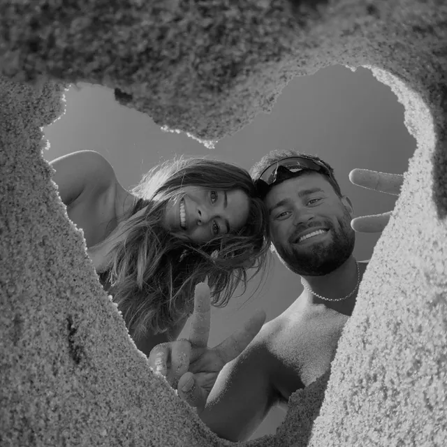 Julie and Jake seen through a heart in the sand